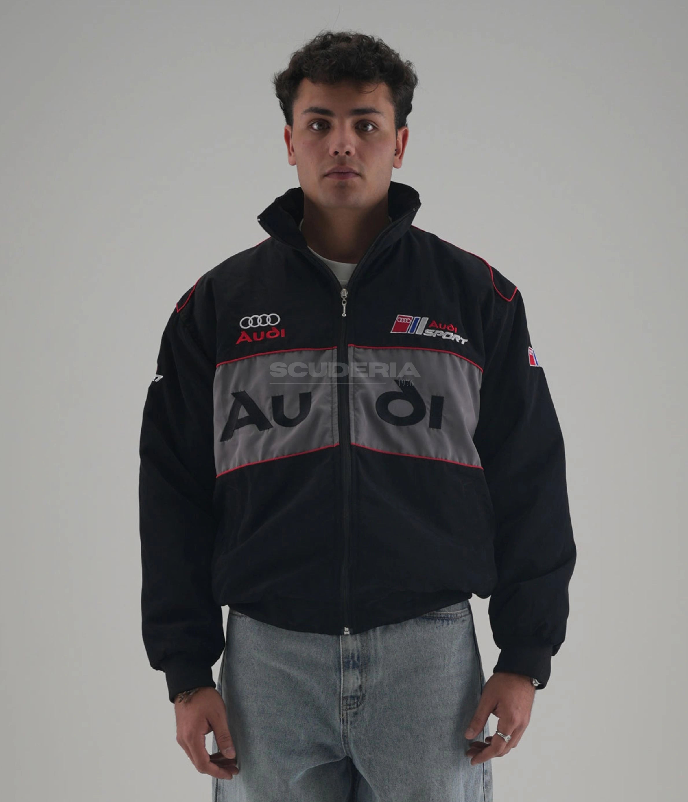 Person wearing an Audi Scuderia jacket on a plain background