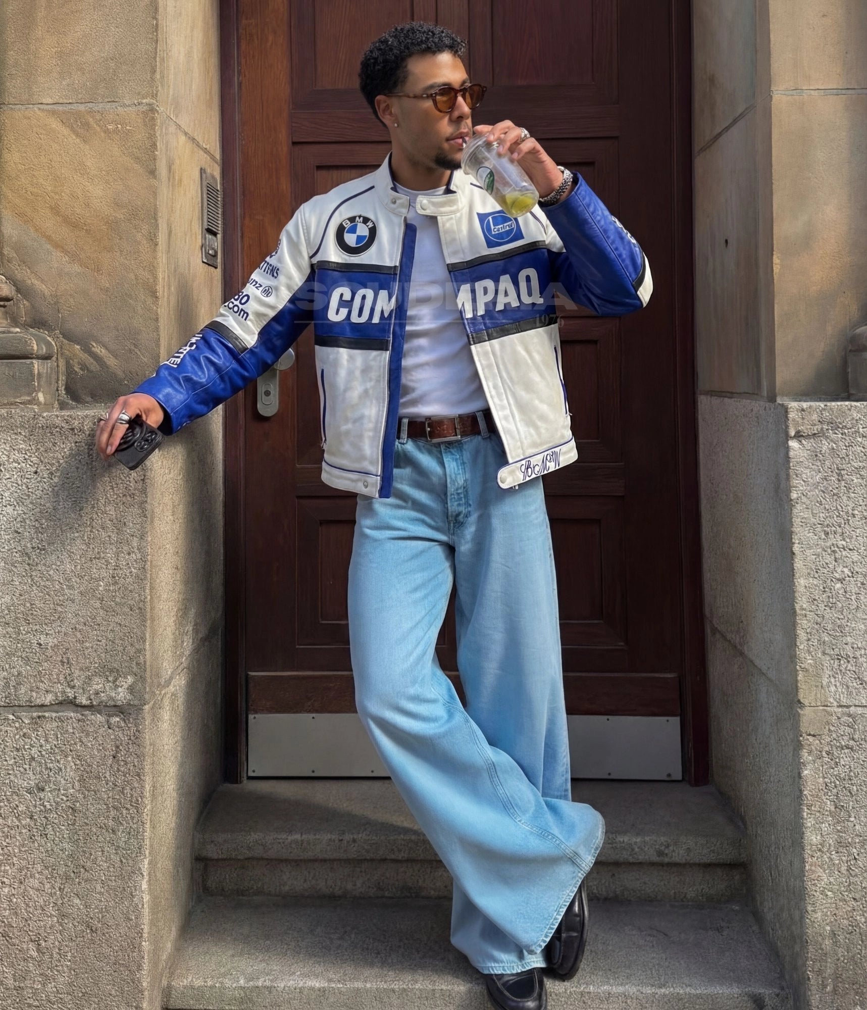 MW Vintage Leather Jacket white blue back view men – vintage moto leather jacket with large Compaq panel on back, blue sleeves with Nortel Networks and Reuters lettering, black piping detail