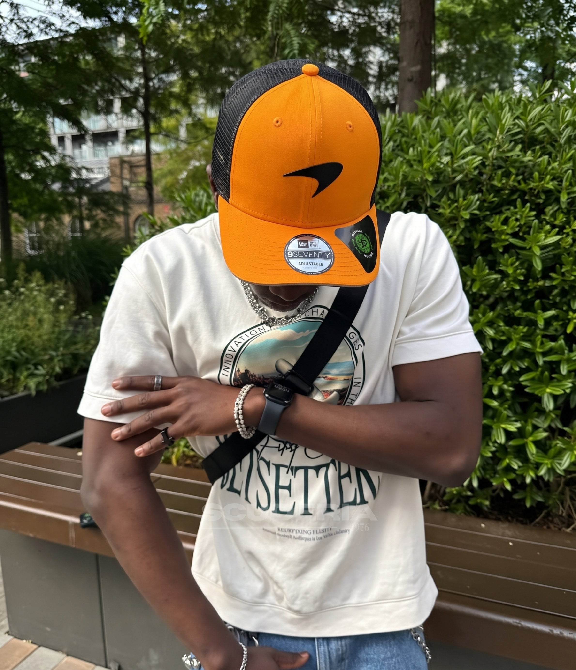 Man wearing the papaya McLaren F1 trucker cap in a park