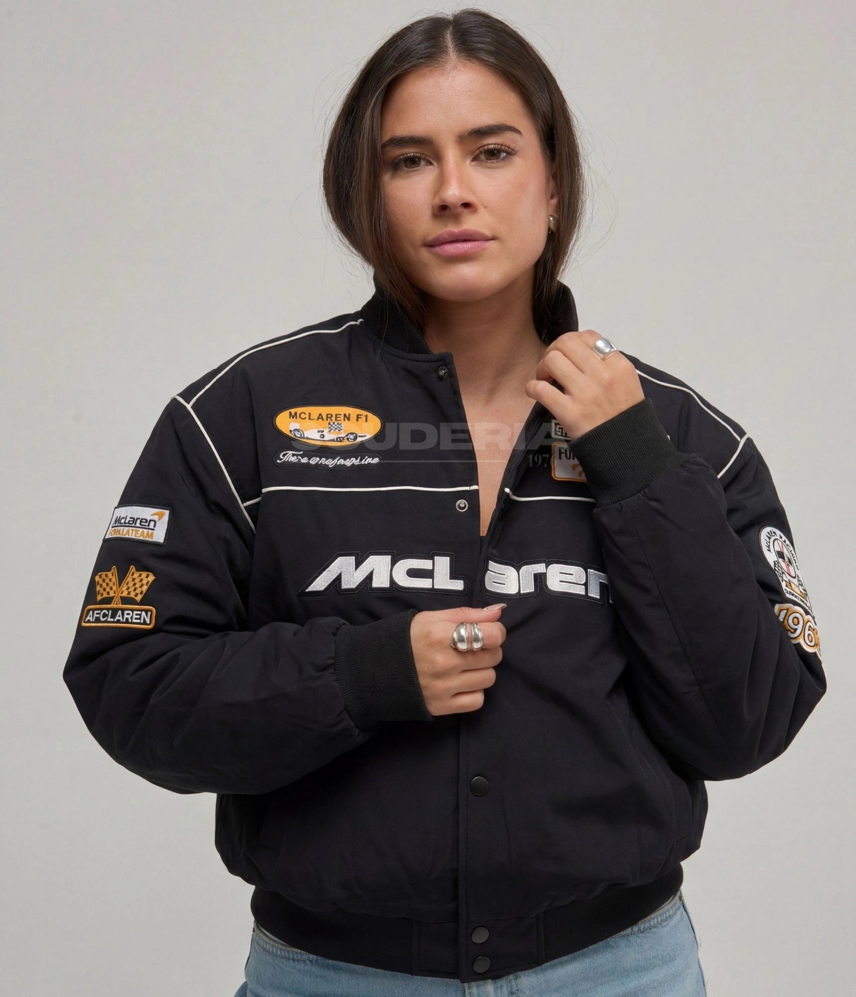 McLaren F1 Racing Jacket black front view women – vintage racing bomber with embroidered McLaren logo, McLaren F1 oval patch, Formula 1 Racing Team patch, AFCLaren and 1963 sleeve patches, white piping detail