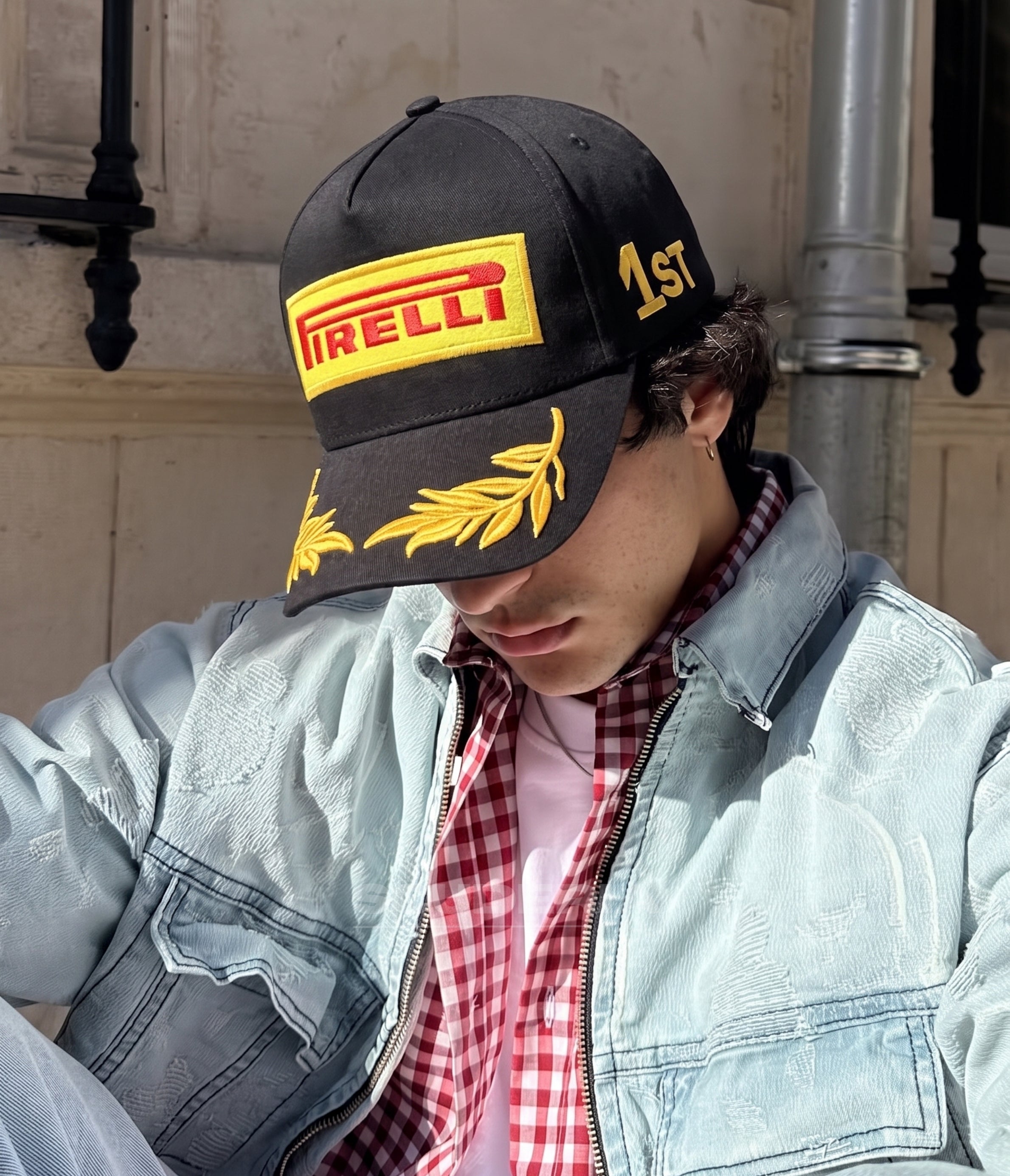 Man wearing the black Pirelli podium winner cap on a city street