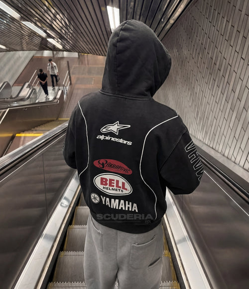 Yamaha Alpinestars Racing Hoodie black washed lifestyle man – vintage oversized motorsport sweatshirt with Alpinestars chest logo, street style with dark baggy jeans and cap outdoors